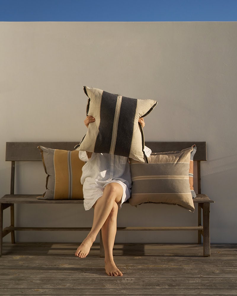 Model holding up the Lisburn cushion in Navy
