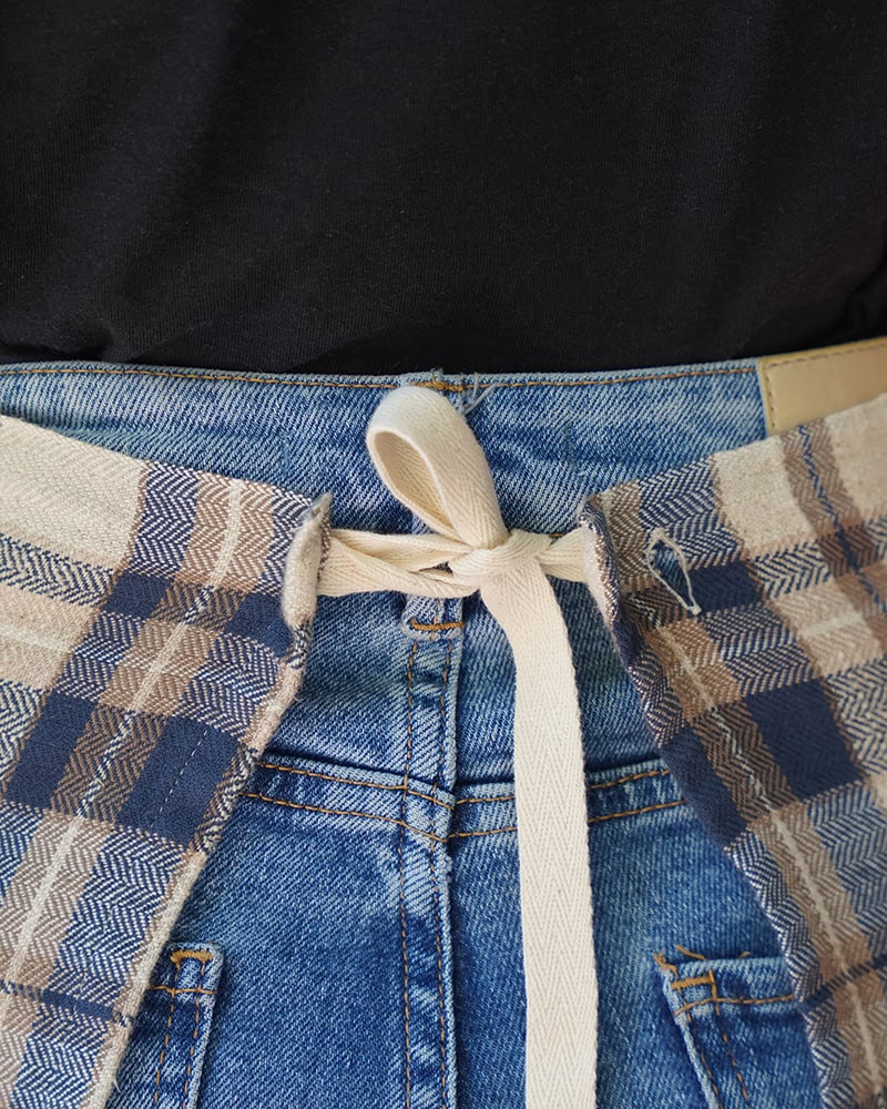Back view of the Cooks cloth functionalities, strap it around your waist, use it as a towel, and button it up as a napkin around the dinner table.