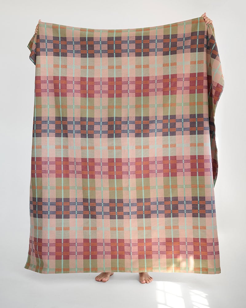Holding up 100% cotton Mungo picnic blanket in Pilgrim